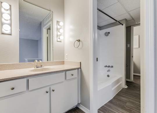 a bathroom with a sink and a shower and a mirror at Falls on Clearwood Apartments, Richardson, TX, Texas