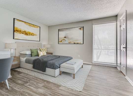 a bedroom with a bed and a desk and a window at Falls on Clearwood Apartments, Richardson, TX, Texas