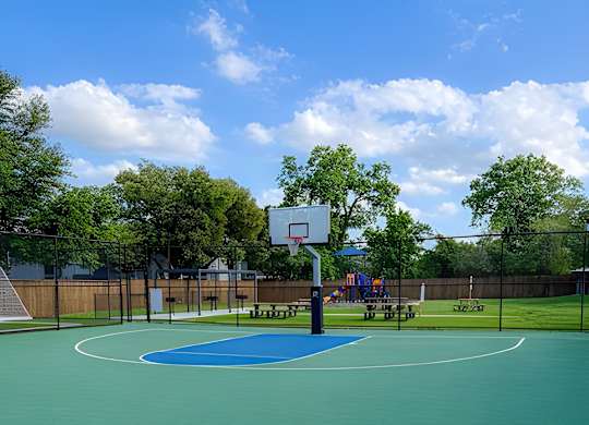 A basketball court with a blue surface and a basketball hoop.