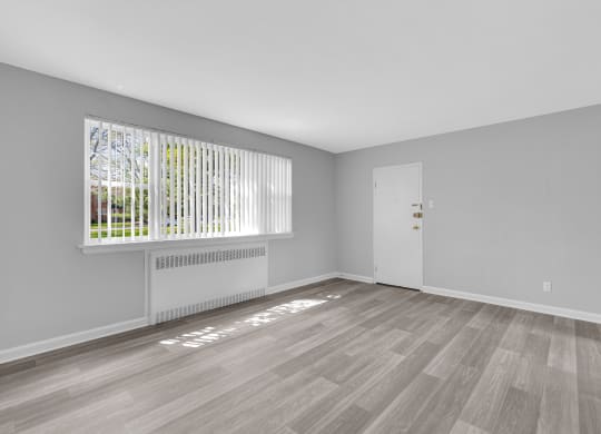 a bedroom with hardwood floors and grey walls at Hampton Gardens, Saint Louis, MO, 63139