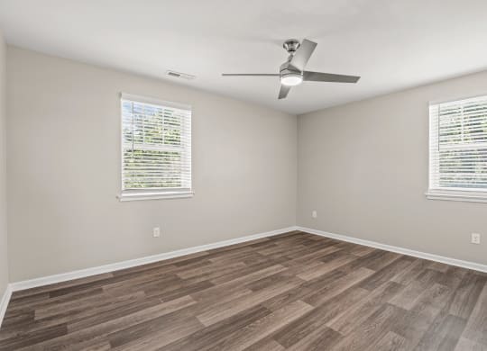 an empty room with a ceiling fan and two windows at Hampton Gardens, Saint Louis, MO, 63139 