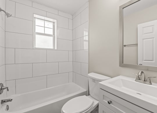 a bathroom with a white sink and toilet and a white bathtub at Hampton Gardens, Saint Louis, MO, 63139