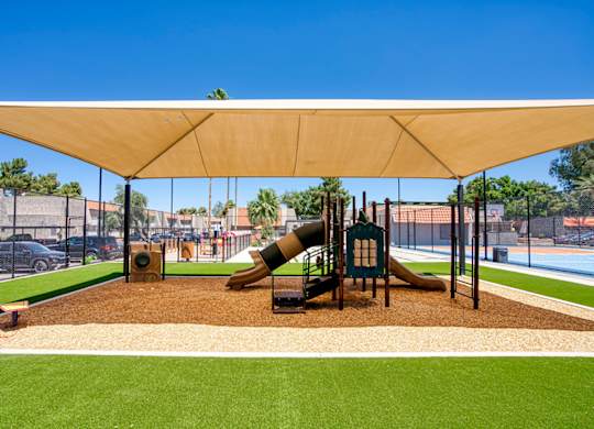 A playground with a slide and a canopy.