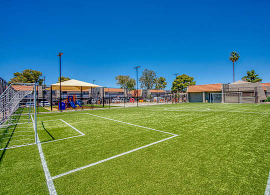 A tennis court with a white line and a yellow canopy tent.