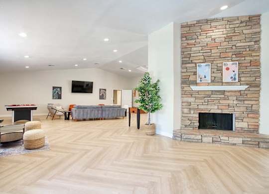 A living room with a stone fireplace and a television.