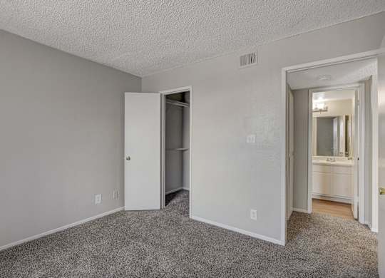 A room with a white door and a carpeted floor.