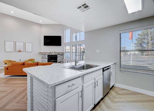 A modern kitchen with a white marble island and stainless steel appliances.