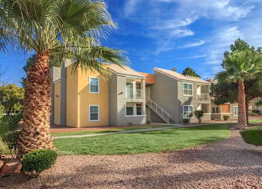 A sunny day at a residential complex with palm trees and a clear blue sky.