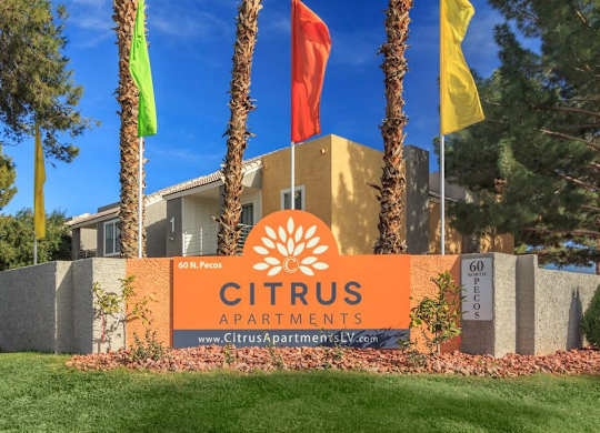 A sign for Citrus Apartments is displayed in front of a building.