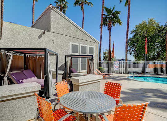 A patio with a table and chairs is set up outside a house.