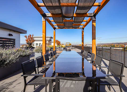 A long table with chairs and a roof is in the foreground of the image.