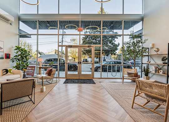 A modern waiting area with a glass wall and wooden floors.