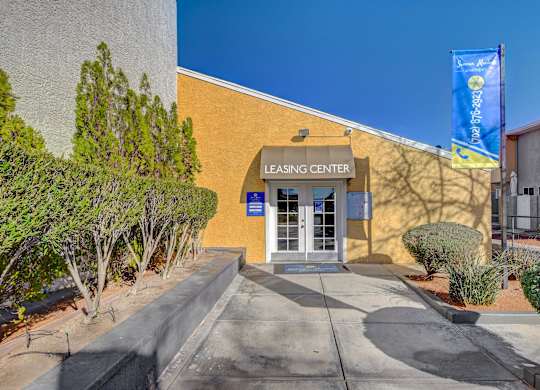 The image shows the entrance to a leasing center with a blue banner hanging above the door.