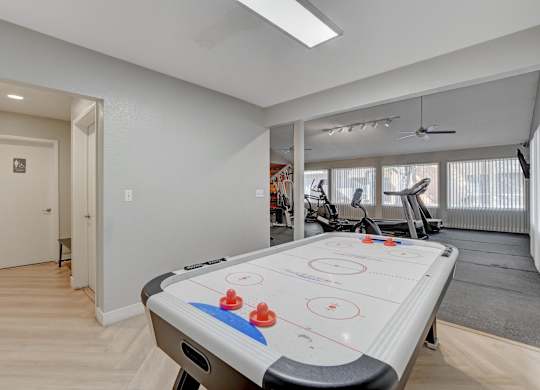 A room with a foosball table in the middle.