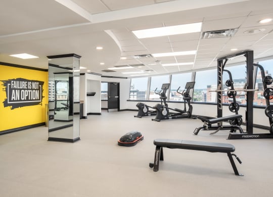 a workout room with weights and other exercise equipment in a building with a large window at Vision on Lombard, Baltimore, MD 21201