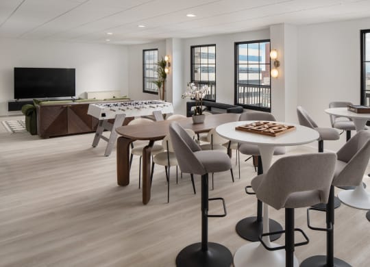a living room with tables and chairs and a television at Vision on Lombard, Baltimore, MD 21201
