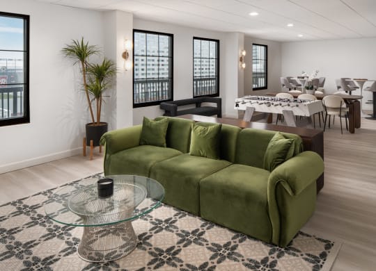 a living room with a green couch and a glass coffee table at Vision on Lombard, Baltimore, MD 21201