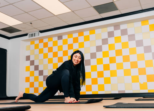 a woman doing yoga in a room with a yellow and white wall at Vision on Lombard, Baltimore, MD 21201