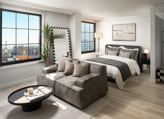 a living room with a couch and a bed in a bedroom at Vision on Lombard, Baltimore, MD 21201