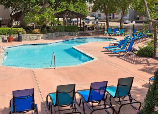 Swimming Pool Area With Shaded Chairs at Foxborough Apartments, Irving