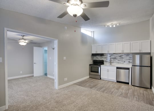a living room with a ceiling fan and a kitchen with stainless steel appliances at Valencia Park, Phoenix, Arizona, 85008