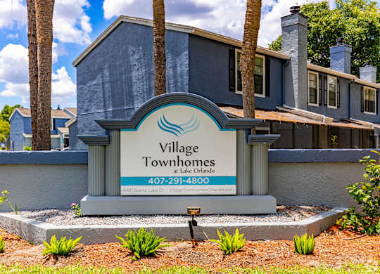 a village townhomes sign in front of a house