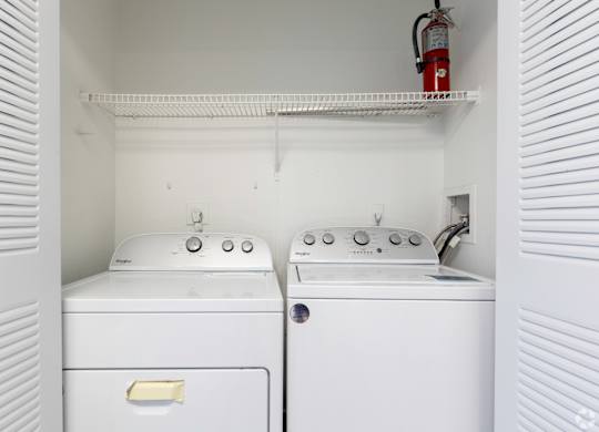 an empty laundry room with two washes and a dryer
