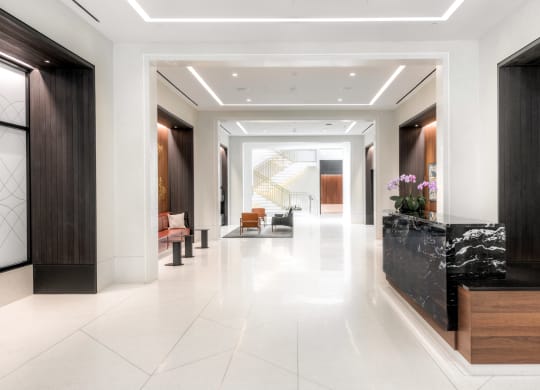lobby with concierge desk, seating and fireplace at the grace apartments in arlington, va
