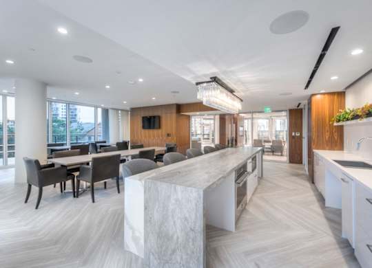 A modern kitchen with a marble island and wooden accents.