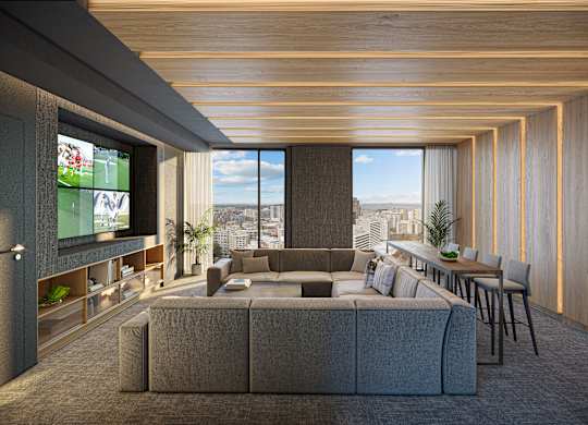 A modern living room with a large grey sofa and a television on the left side.