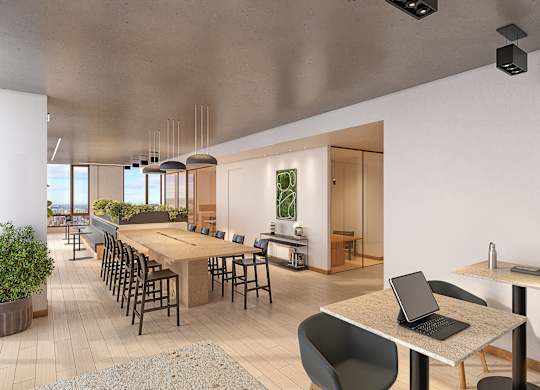 A modern office space with a long table, chairs, and a laptop on a table.