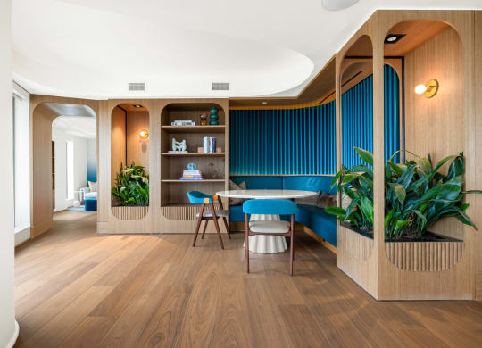 a room with a table and chairs and a blue wall with plants at The Grace and Reva, Arlington