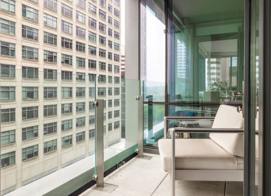a room with a view of a skyscraper and a chair