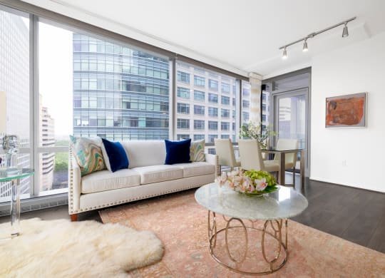 a living room with a couch and a table in front of a window