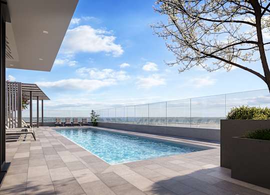 A modern pool area with a clear blue sky.