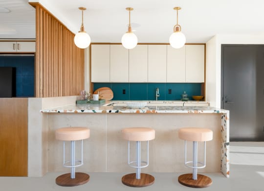 a kitchen with pink stools and white cabinets and a counter at The Grace and Reva, Virginia