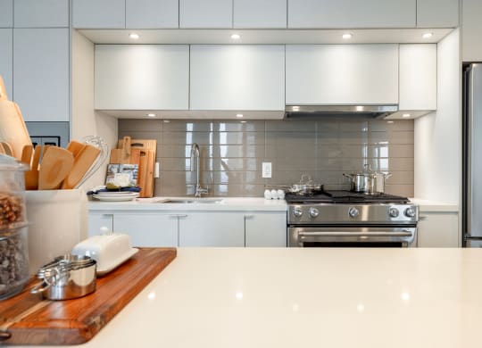 a large white kitchen with stainless steel appliances and white counter tops