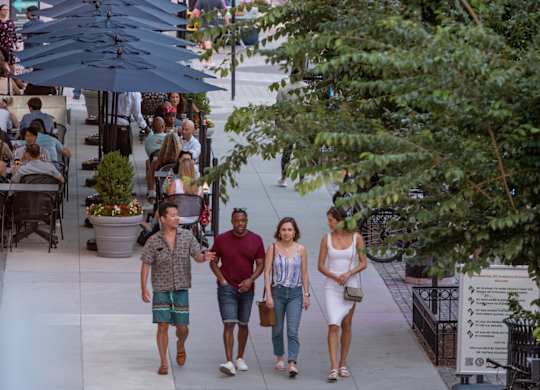 A group of people walking down a sidewalk in a city.