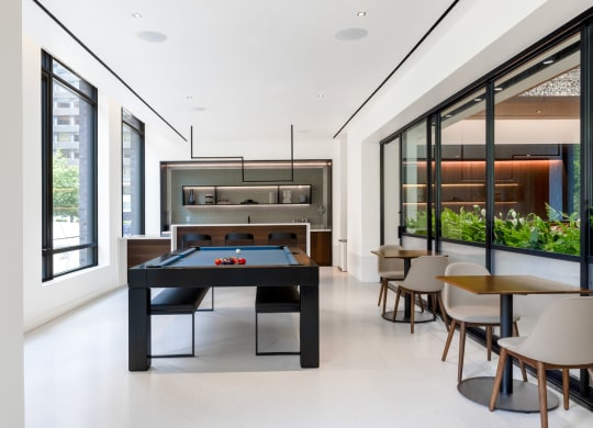 a black pool table in the center of a room with tables and chairs at The Grace and Reva, Virginia, 22202