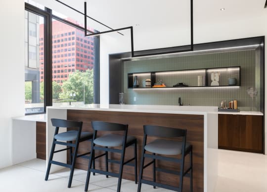 a kitchen with a bar and three stools in front of a window at The Grace and Reva, Virginia