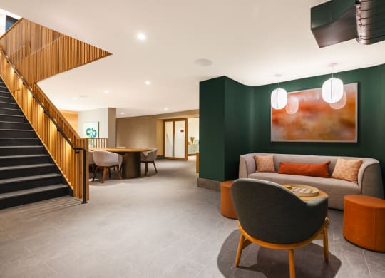 a lounge area with chairs and tables and a staircase at The Grace and Reva, Arlington, VA
