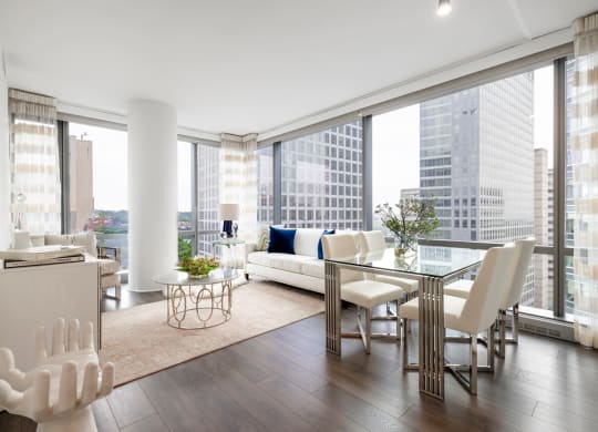 a living room with a large window and a table with chairs