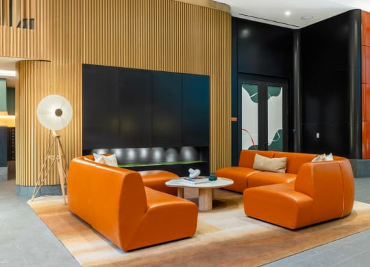 a living room with orange couches and a table at The Grace and Reva, Arlington, 22202