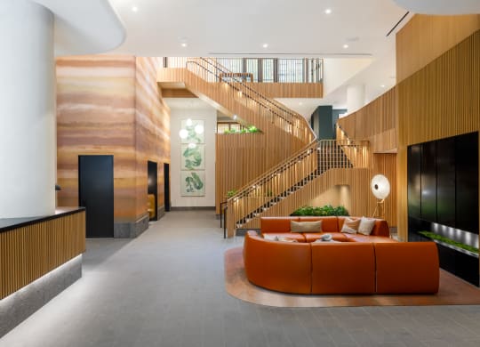 a large living room with an orange couch and a staircase at The Grace and Reva, Arlington, 22202