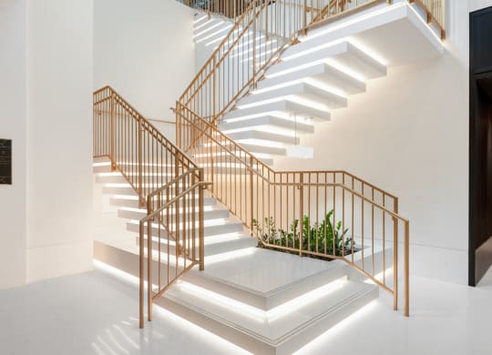 a staircase with wooden railing and white stairs at The Grace and Reva, Arlington, VA