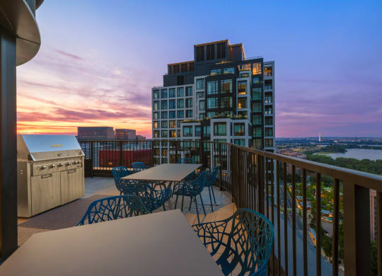a balcony with a view of a city and a sunset at The Grace and Reva, Arlington, VA