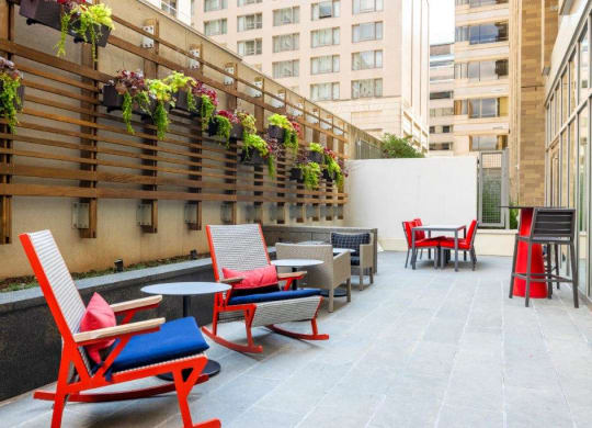 a patio with chairs and tables on a building