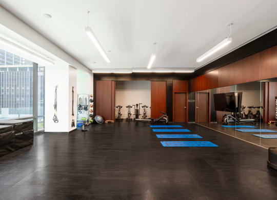 a workout room with weights and cardio equipment in a large room