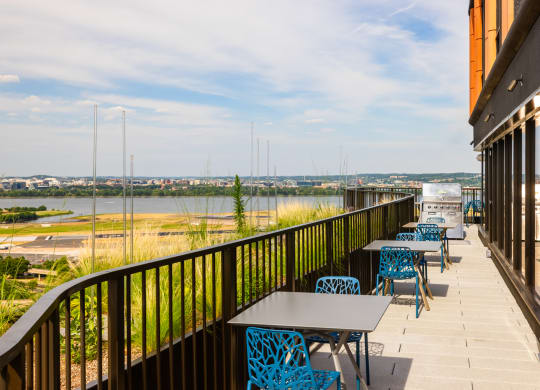 a balcony with tables and chairs and a view of a river at The Grace and Reva, Arlington