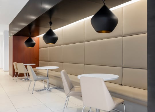 a restaurant with white tables and chairs and lights on the ceiling